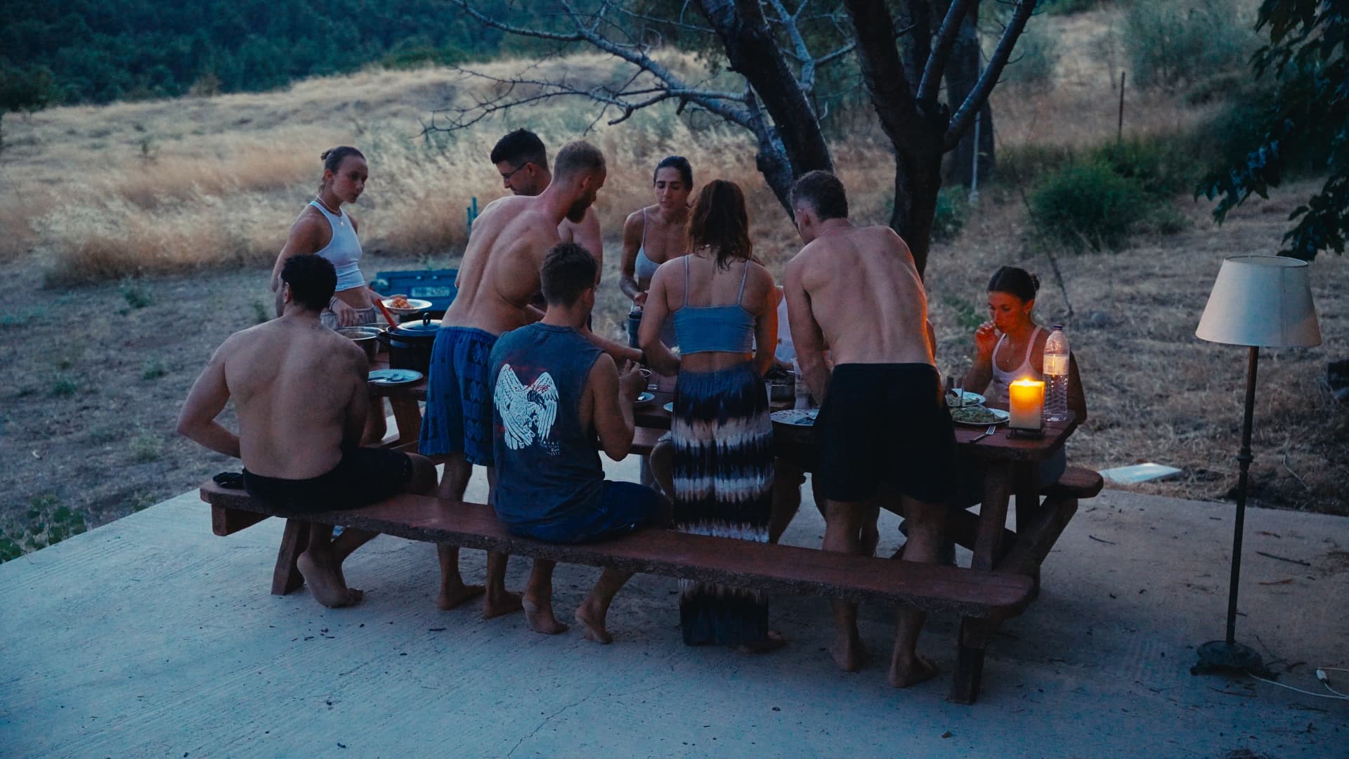 Residents sharing dinner outdoors by candlelight